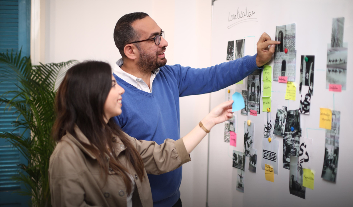 UX researchers generated ideas about the strategy for UX localization, observing a whiteboard adorned with sticky notes. 