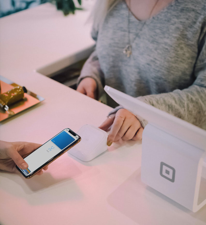 A customer happily using their phones at checkout, highlighting the importance of understanding user journey maps and delivering top-notch service.