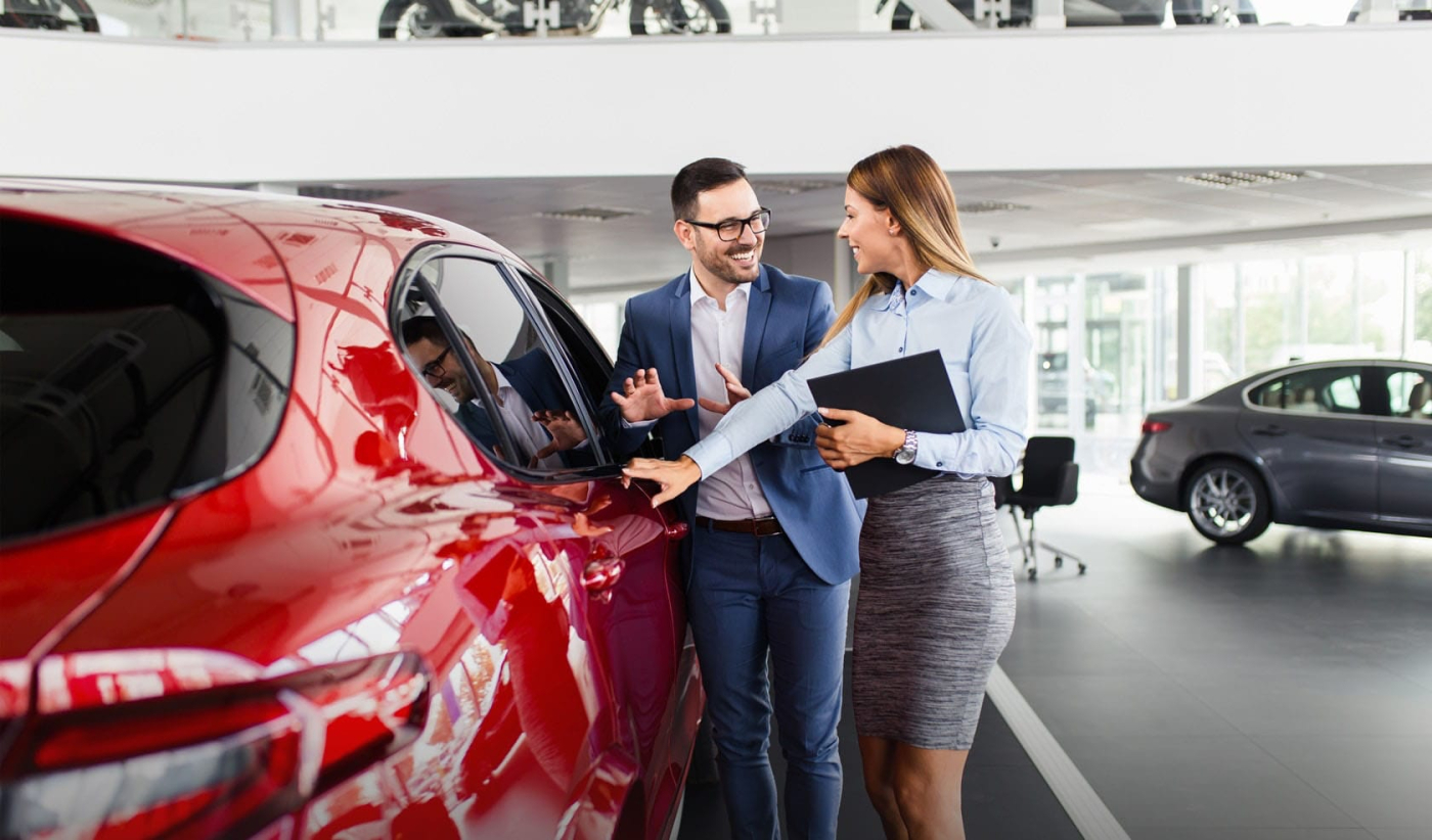 A man and woman engage in mystery shopping research, inspecting a car in a showroom, improvements in the automotive industry